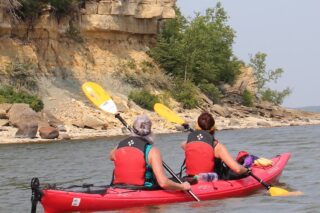 We are excited to venture north to Hecla Island for a 5 hour tour to explore the ancient reminders of a receding Lake Agassiz. Hecla is characterized by a peninsula of land, a series of islands and adjacent waters in Lake Winnipeg. Landscapes include coniferous and mixed forests, limestone cliffs, and silica sand beaches. Depending on lake conditions, we will be paddling north to Punk Island, just north of Hecla. There we will relax on a limestone rock beach and share in a shore lunch. Reserve your spot today!
Previous lake kayaking experience is required. Continuous paddling for an hour or more should be anticipated as we are out on Lake Winnipeg in potentially challenging conditions. Paddling in a double kayak is an option for participants. Lake paddling instruction and rescue techniques are provided.
The Hecla Tours take place in August 1st and September 5th.
See you on the Big Lake at Hecla!